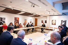 Novák Katalin ölelkező férfiakat ábrázoló fotó társaságában fogadta vendégeit Brüsszelben